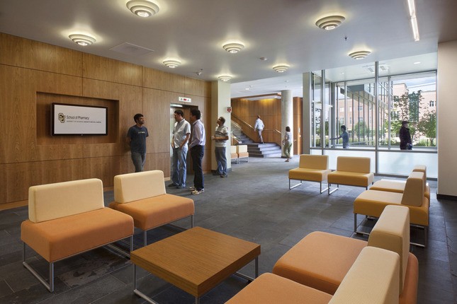 lobby area with wood wall and orange seating