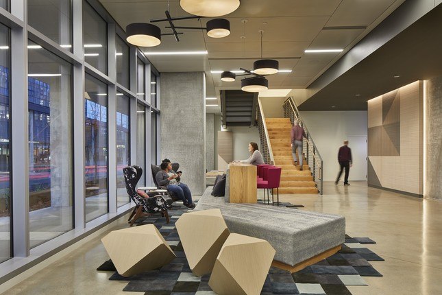 People sitting in lobby with a staircase at the AMLI Arc