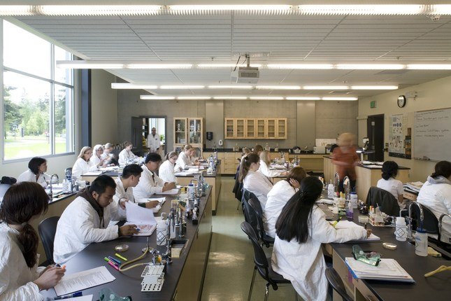 Students in lab coats in a classroom
