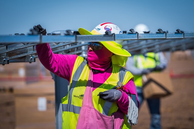 worker installing solar panels