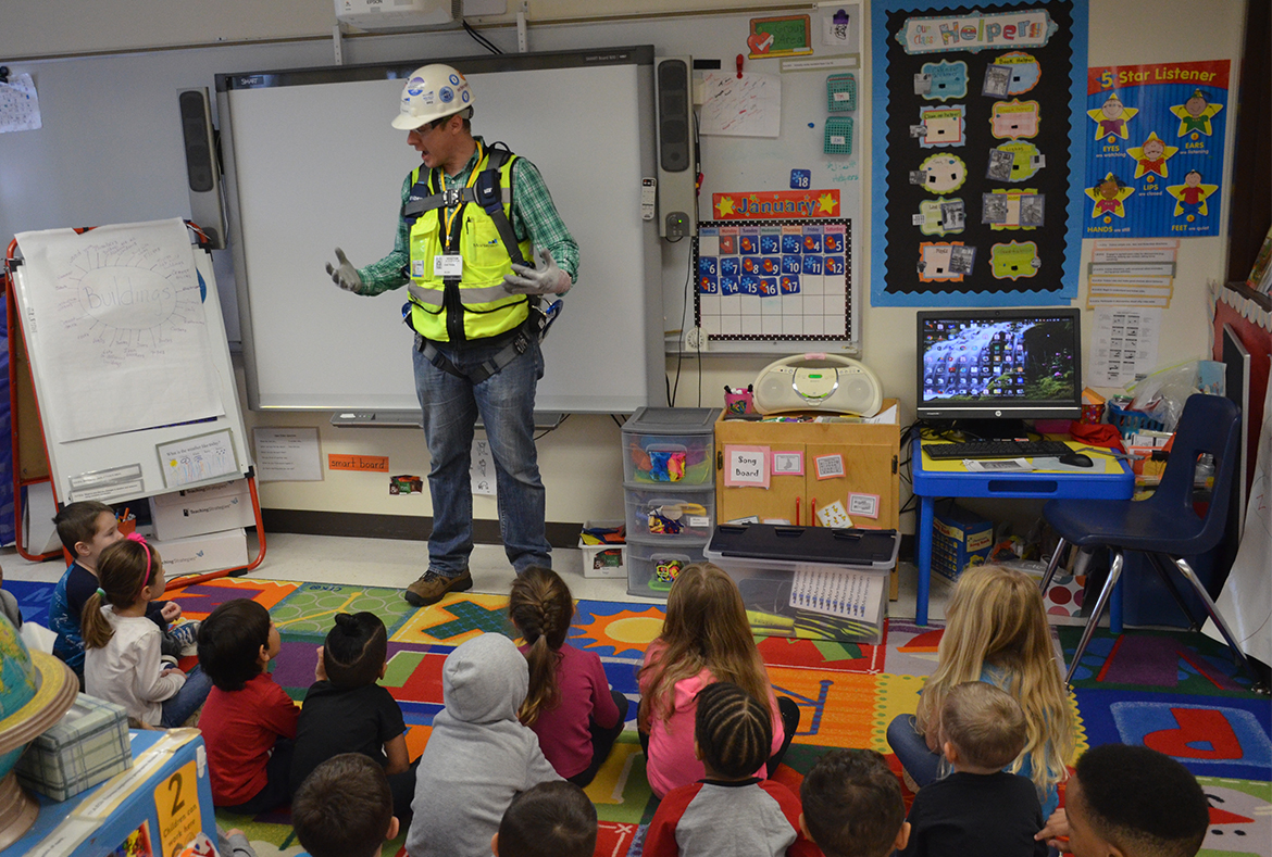 Construction worker reading to school kids