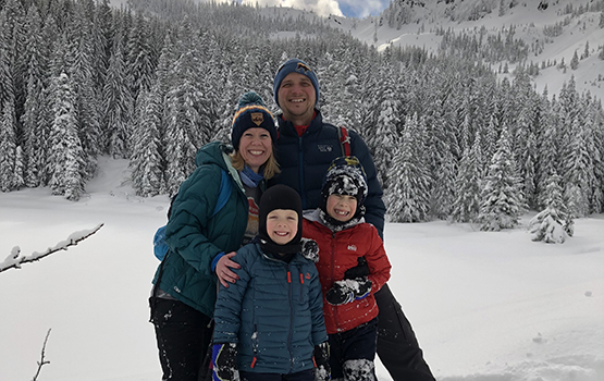 Family in snow smiling at camera
