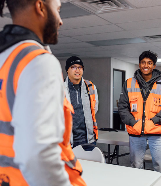 diverse construction workers in orange vests