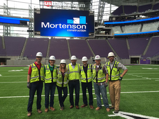 group of Mortenson construction managers on field at US Bank Stadium