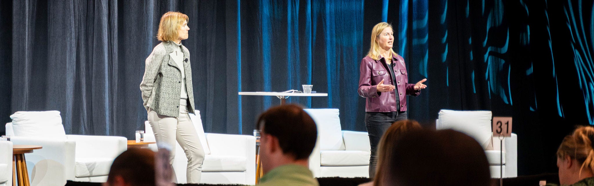 Two speakers presenting on conference stage