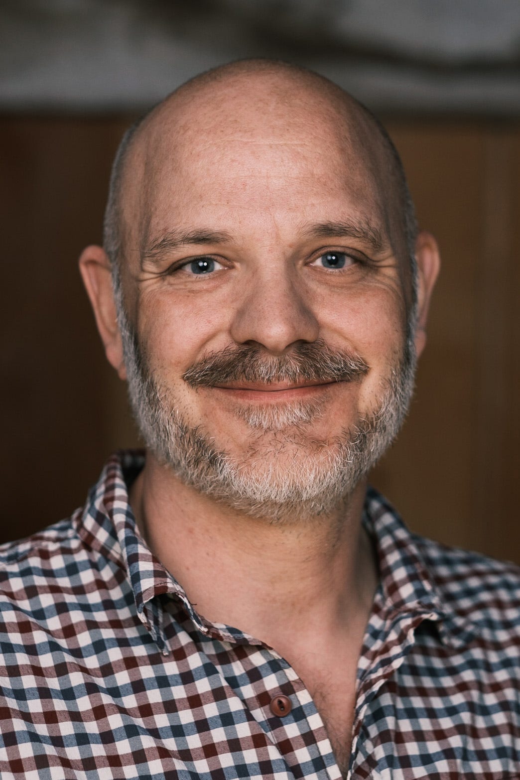 Smiling middle-aged man in checkered shirt