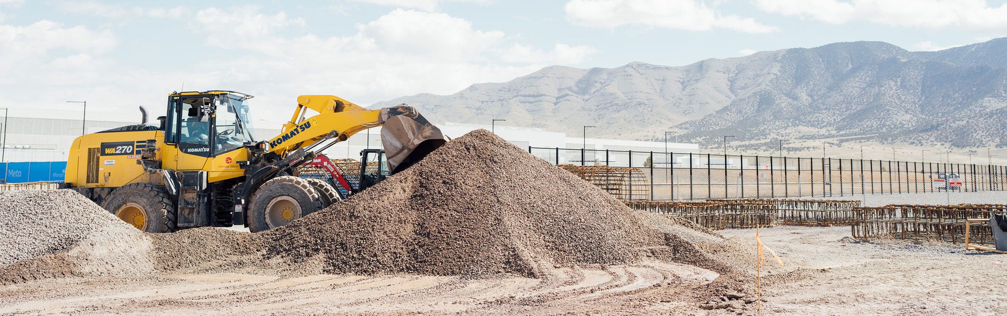 Yellow wheel loader moving gravel at site
