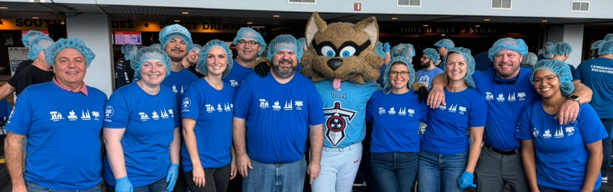 Group photo with mascot in blue shirts