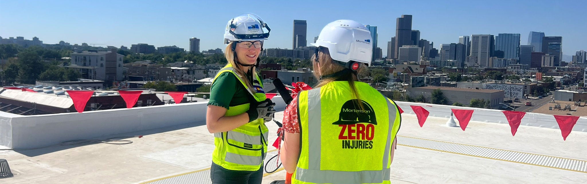 Construction workers on rooftop with city view