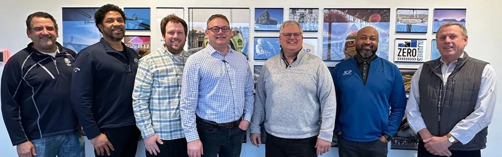 Group of Men Standing in Office with Wall Art