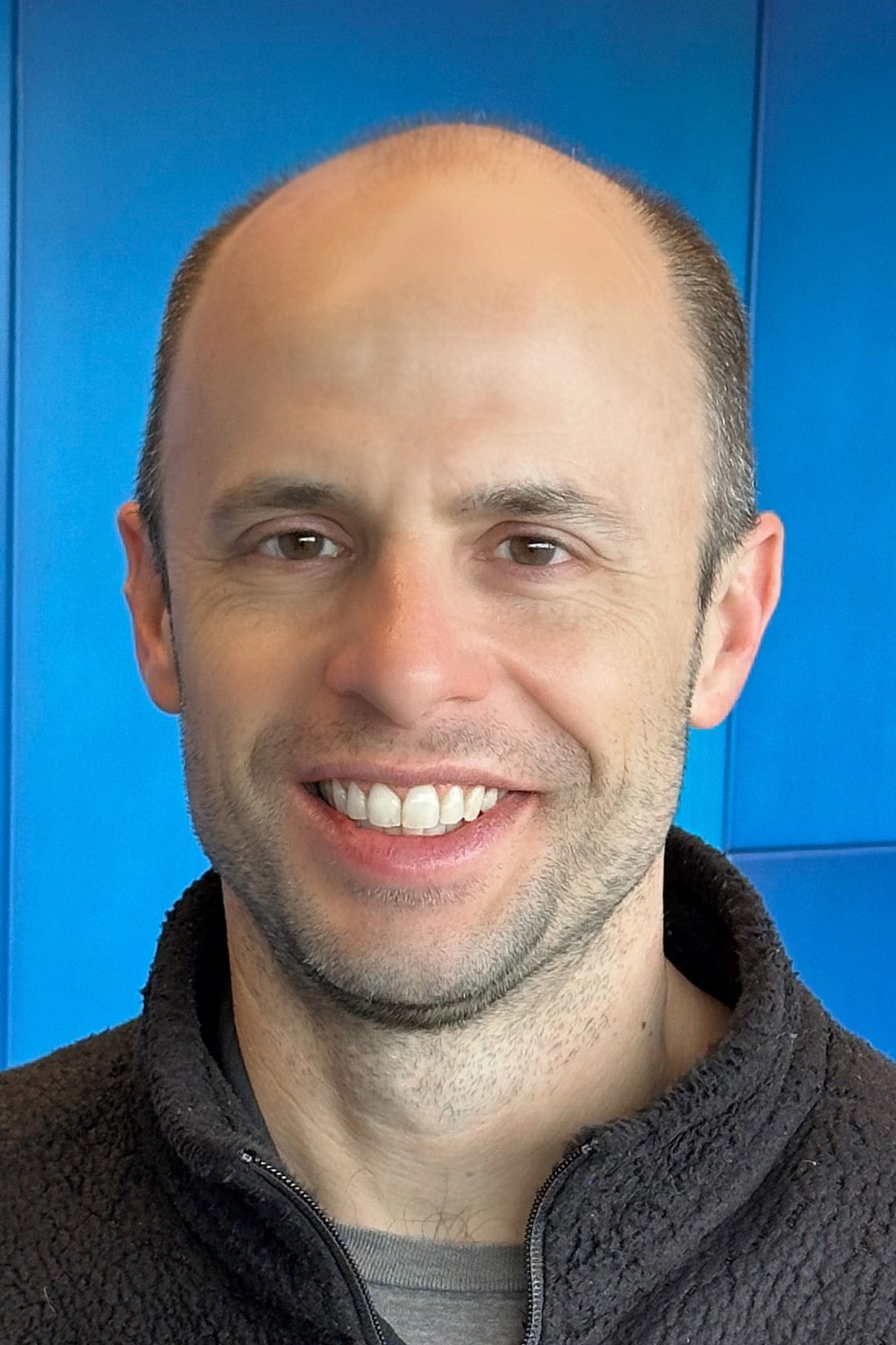 Man in fleece jacket against blue background